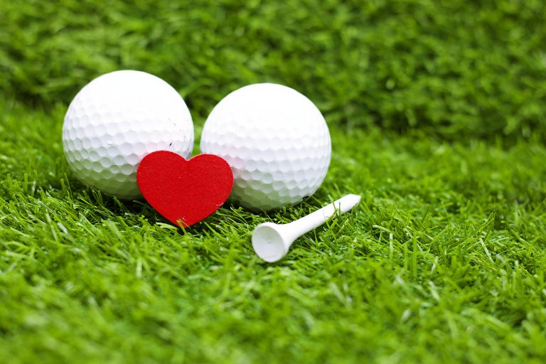 Golf ball with red heart love on green grass McCormick Woods Golf Club